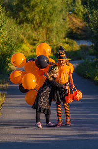 Rear view of woman with balloons on road