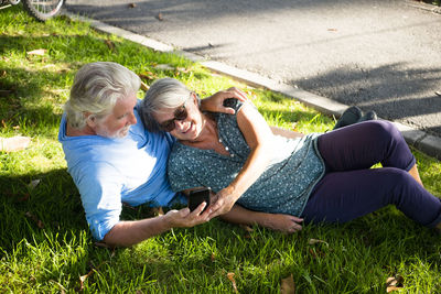 Rear view of woman photographing on grass
