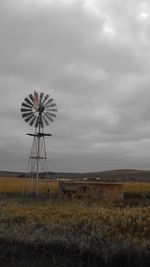 Traditional windmill on field against sky