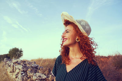 Close-up of young woman against sky