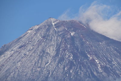 Low angle view of volcanic mountain against sky