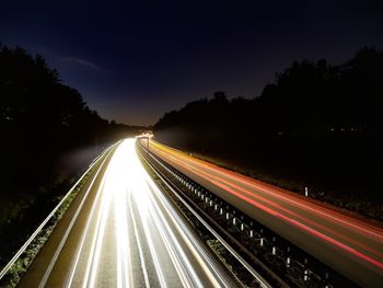 High angle view of light trails on highway at night