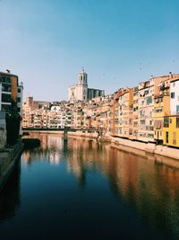 Onyar river amidst buildings against clear blue sky