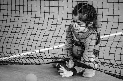 High angle view of girl holding net at tennis court