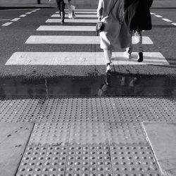 Low section of woman walking on road