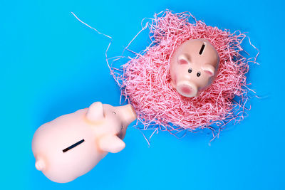 High angle view of piggy banks on blue background