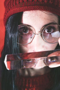 Close-up portrait of woman holding mirror