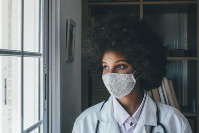 Doctor wearing flu mask looking away at hospital