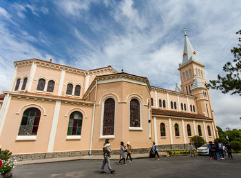 People in front of historic building against sky