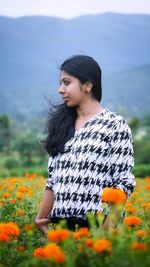 Beautiful woman looking away while standing on field