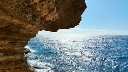 Rock formation and sea against sky