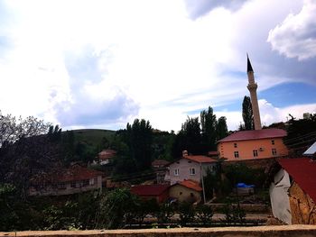 Panoramic view of buildings and trees against sky