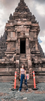 Woman sitting on historical building