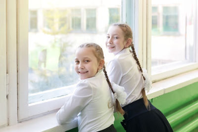 Portrait of happy girl standing by window