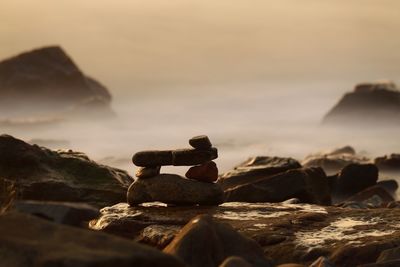 Stack of rocks on land against sky