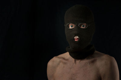 Portrait of shirtless man against black background