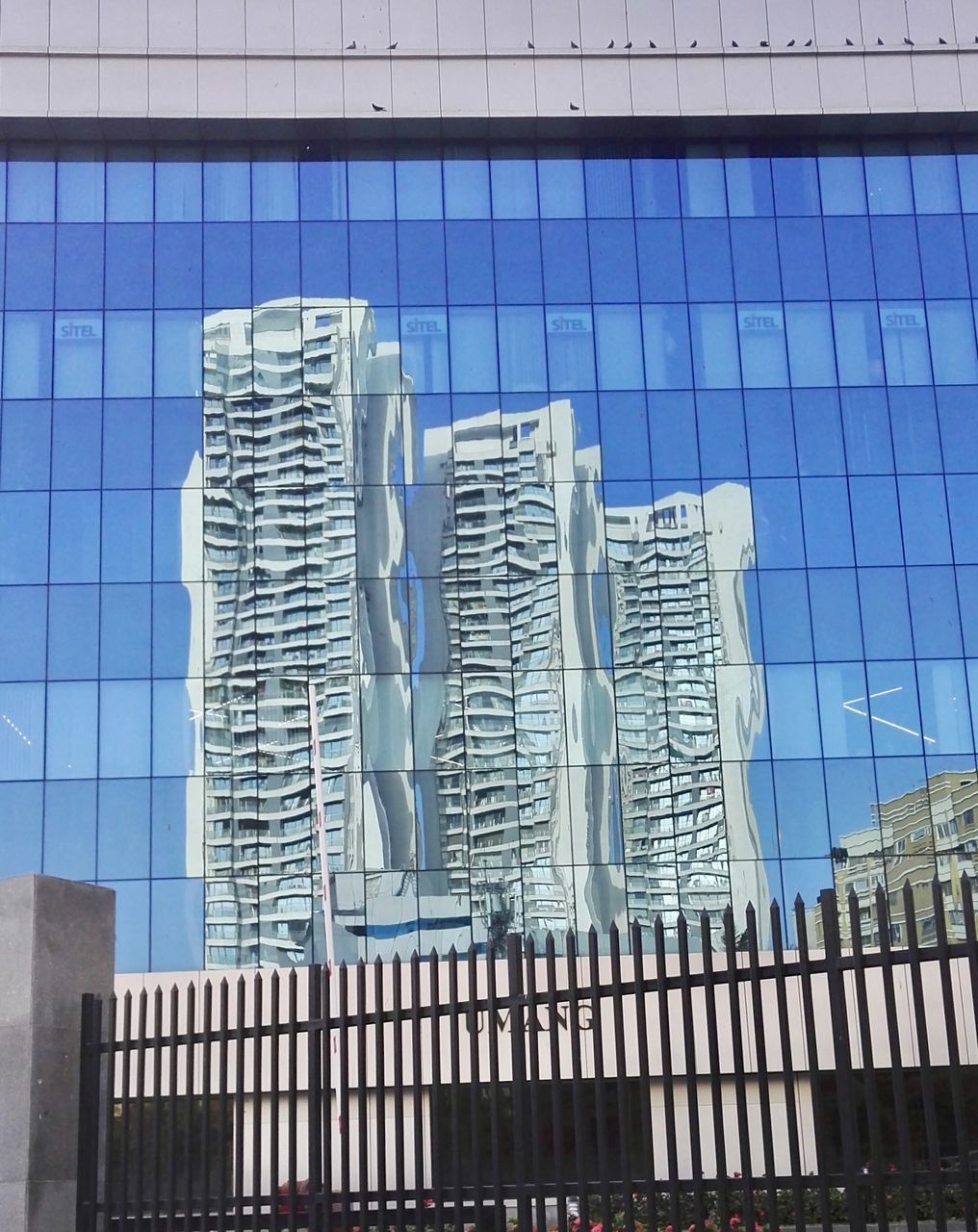 DIGITAL COMPOSITE IMAGE OF MODERN GLASS BUILDING IN CITY