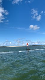 Man standing in sea against sky