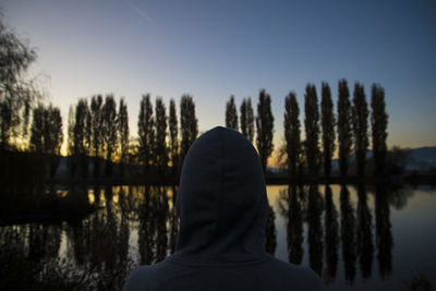 Rear view of man on lake against sky