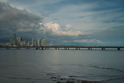 Scenic view of sea by buildings against sky