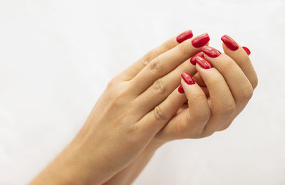 Cropped hand of woman gesturing against white background