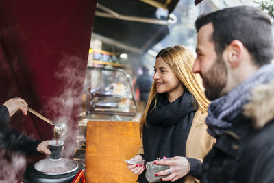 Uk, london, young couple trying punch at market stall