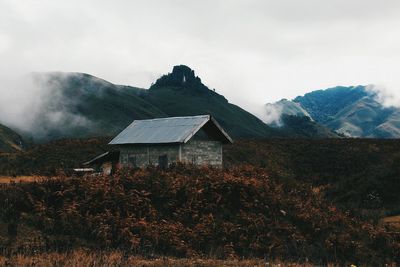 House on mountain against sky