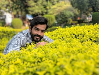 Portrait of smiling young man by yellow plants