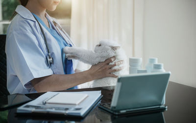 Midsection of doctor examining patient at clinic