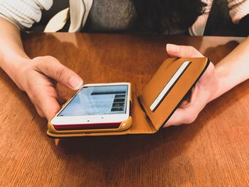 Close-up of woman using mobile phone on table at home