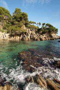 Scenic view of rocks in sea against sky