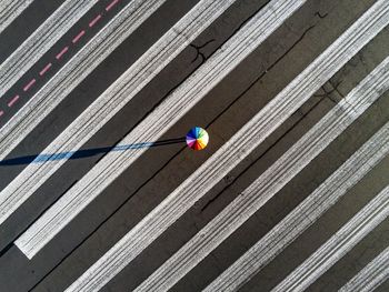 Aerial view of colorful umbrella on road during sunny day