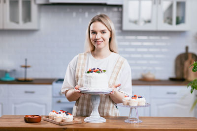 Portrait of smiling female chef holding cake
