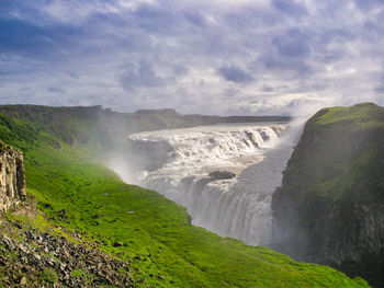 Scenic view of waterfall against sky