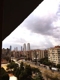 View of cityscape against cloudy sky