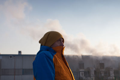 Rear view of young woman standing against sky