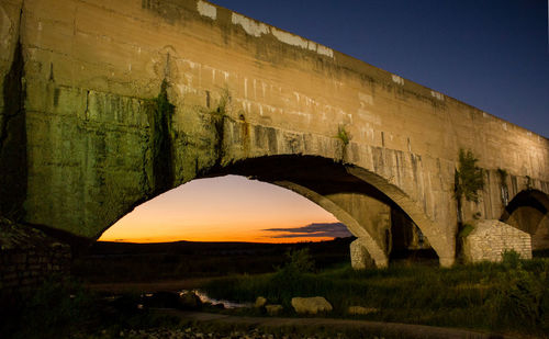 Arch bridge against clear sky at night