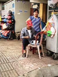 Portrait of friends sitting on street