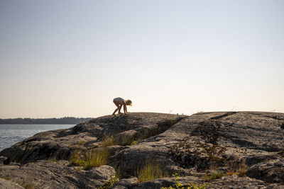Child climbing on rocky shore