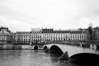 Bridge over river against buildings in city