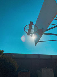 Low angle view of illuminated street light against blue sky