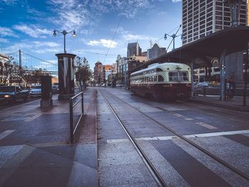 View of railroad tracks by buildings against sky