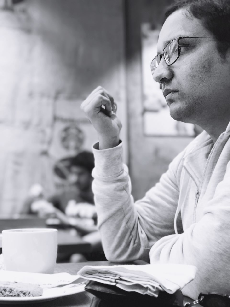 real people, concentration, one person, artist, indoors, young men, education, focus on foreground, eyeglasses, sitting, young adult, paper, classroom, student, learning, university student, men, human hand, day, close-up, people