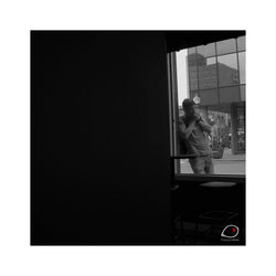 Reflection of man standing on glass window