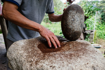 Man grinding coffee with a stone. 