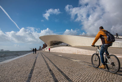 People riding bicycle against sky