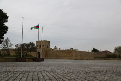 Low angle view of flag on building against sky