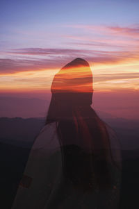 Double exposure of woman and landscape during sunset