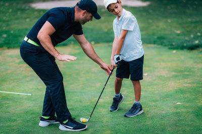 Full length of friends playing on golf course