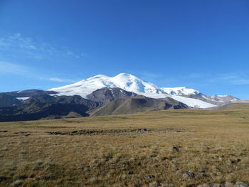 Scenic view of mountains against blue sky